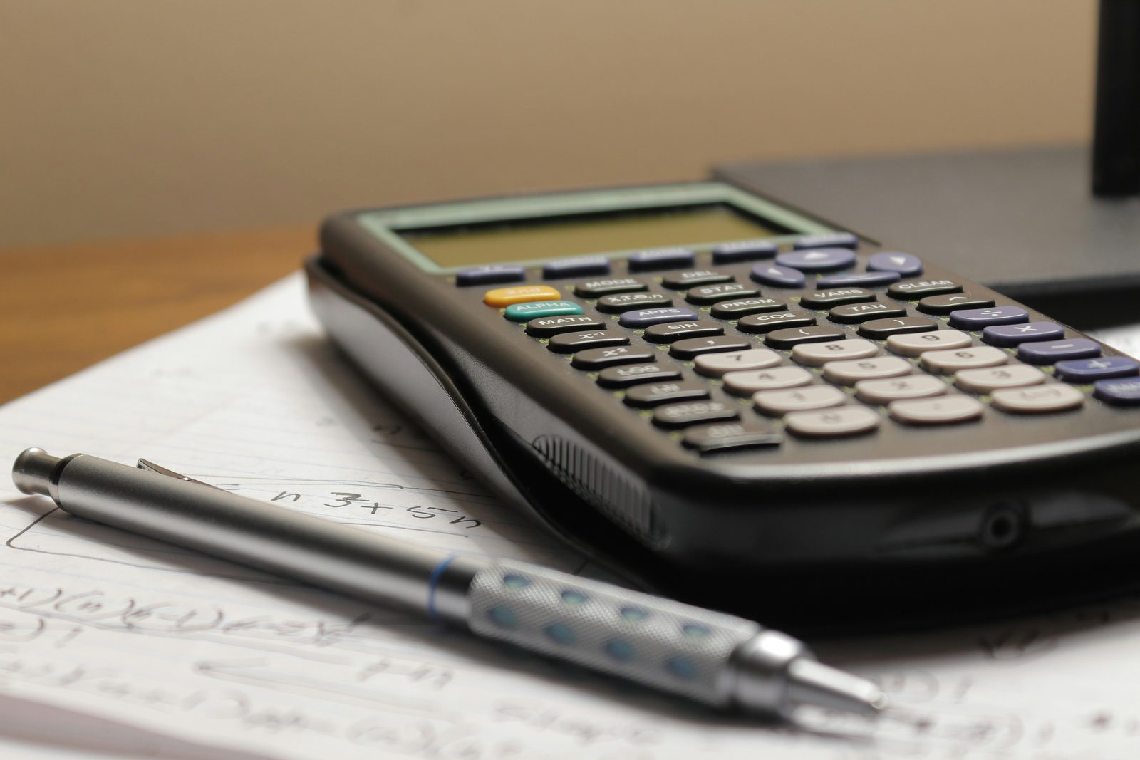 Calculator and handwritten figures on a budget worksheet for planning ADU financing