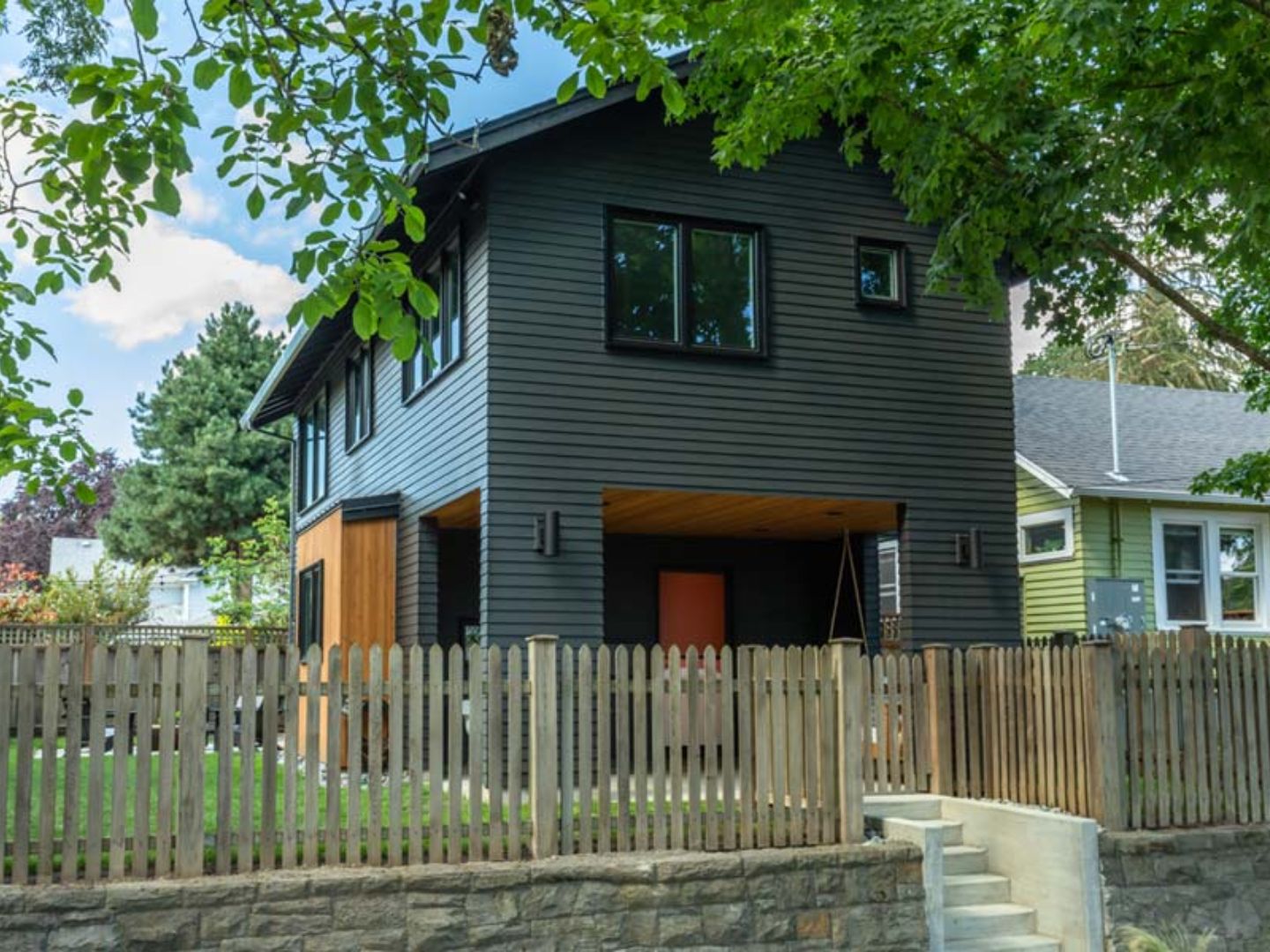 Two-story modern ADU with dark siding in a Bay Area residential backyard